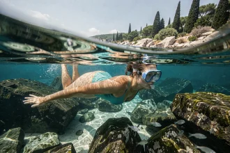 Femme en train de faire du snorkeling au-dessus des fonds rocheux de l'île de Lokrum près de Dubrovnik, Croatie