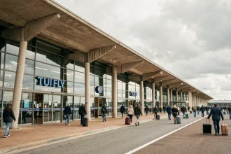 Entrée extérieure du terminal TUI FLY à l'aéroport d'Orly avec voyageurs et signalétique visible